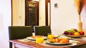 A breakfast table with croissants, fruit, and orange juice. - Casón De Los López Apartments 1B (Toledo)
