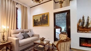 Uma sala de estar com sofá, mesa de centro, lareira e um quadro na parede.