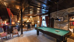 A cozy room with a pool table, wooden furniture, and stone walls. - Quinta Lusitânia (Santa Comba Dao)