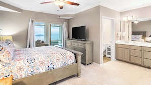 A bedroom with a bed, a dresser, a television, and a bathroom with a sink and mirror. - Majestic Lakeview Destination Unmatched Location (Branson)