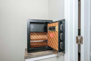 A safe deposit box with a lock and a keyhole, mounted on a wooden shelf. - Historic 4BR 3 Kings Sleeps 10 (Cincinnati)