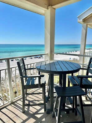 A covered outdoor seating area with a view of the beach and ocean. - Gulf View Getaway at Crystal Villas (Destin)