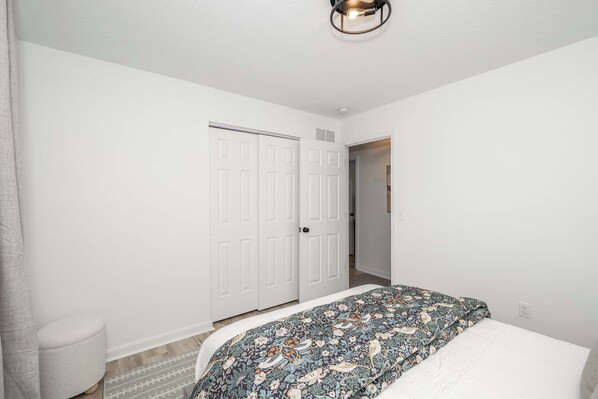A bedroom with a bed, a white door, and a light fixture. - Walton Arkside Oasis (Walton)