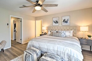 A bedroom with a large bed, a ceiling fan, two bedside lamps, and a nightstand. - Lakeside Hideaway (Horseshoe Bay)