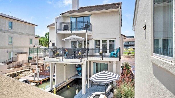 A two-story house with a balcony, a pool, and outdoor furniture. - Lakeside Hideaway (Horseshoe Bay)