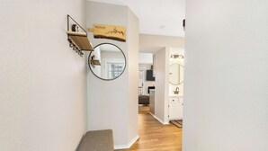A hallway with a bench, a round mirror, and a wooden shelf with a sign. - Chandlers Pondview Getaway Chic Branson Escape (Branson)