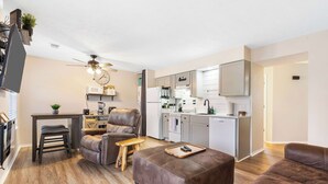 A compact living space with a kitchenette, a dining area, and a seating area with a sofa and a chair. - Chandlers Pondview Getaway Chic Branson Escape (Branson)