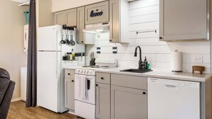 A modern kitchen with white appliances, a stainless steel range hood, and a dishwasher. - Chandlers Pondview Getaway Chic Branson Escape (Branson)