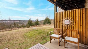 A wooden deck with two wooden chairs and a decorative sign.