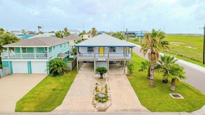 A two-story house with a front porch, a garage, and a well-maintained lawn. - Spacious & Pet Friendly + Game Room Sleeps 10 (Port Aransas)