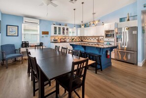 A modern kitchen with white cabinets, a central island, and stainless steel appliances. - Spacious & Pet Friendly + Game Room Sleeps 10 (Port Aransas)