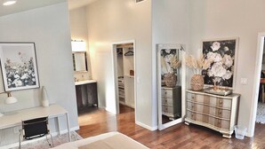 A modern bedroom with a large bed, a desk, and a walk-in closet. - Bellflower Breeze Charming 3 BDR in Long Beach! (Long Beach)