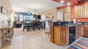 A spacious kitchen with a central island, wooden cabinets, and a built-in dishwasher.