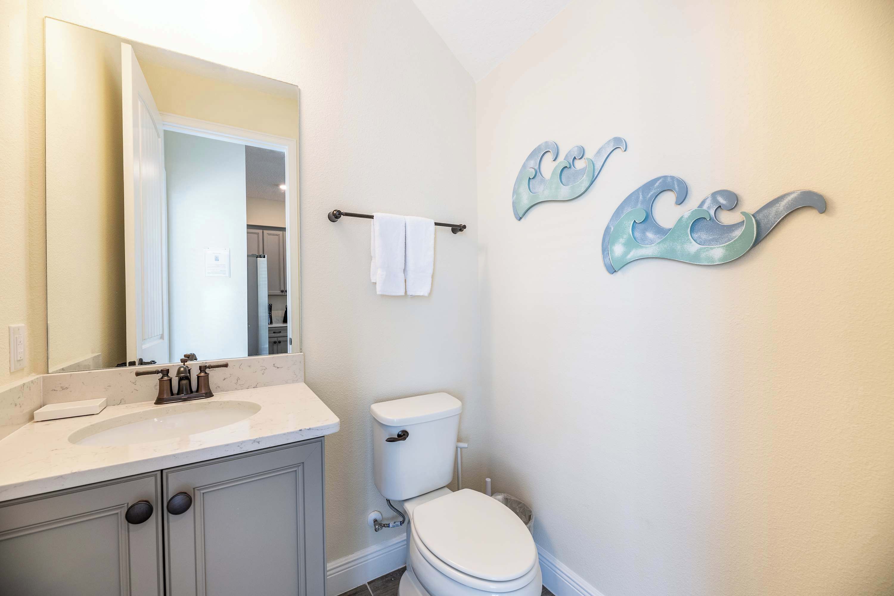 A bathroom with a white sink, a toilet, and a towel rack.