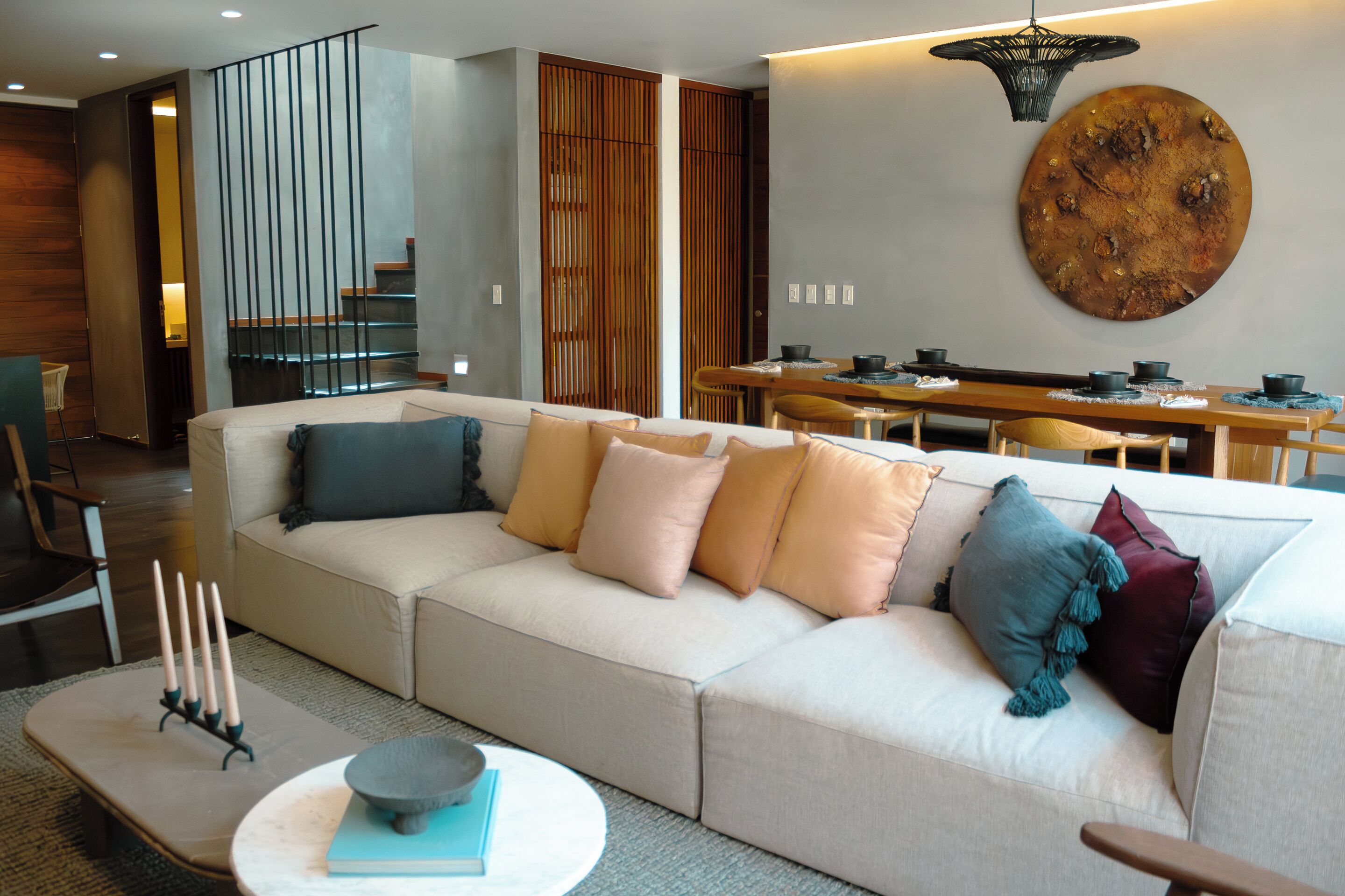 A modern living room with a sofa, coffee table, and dining area.