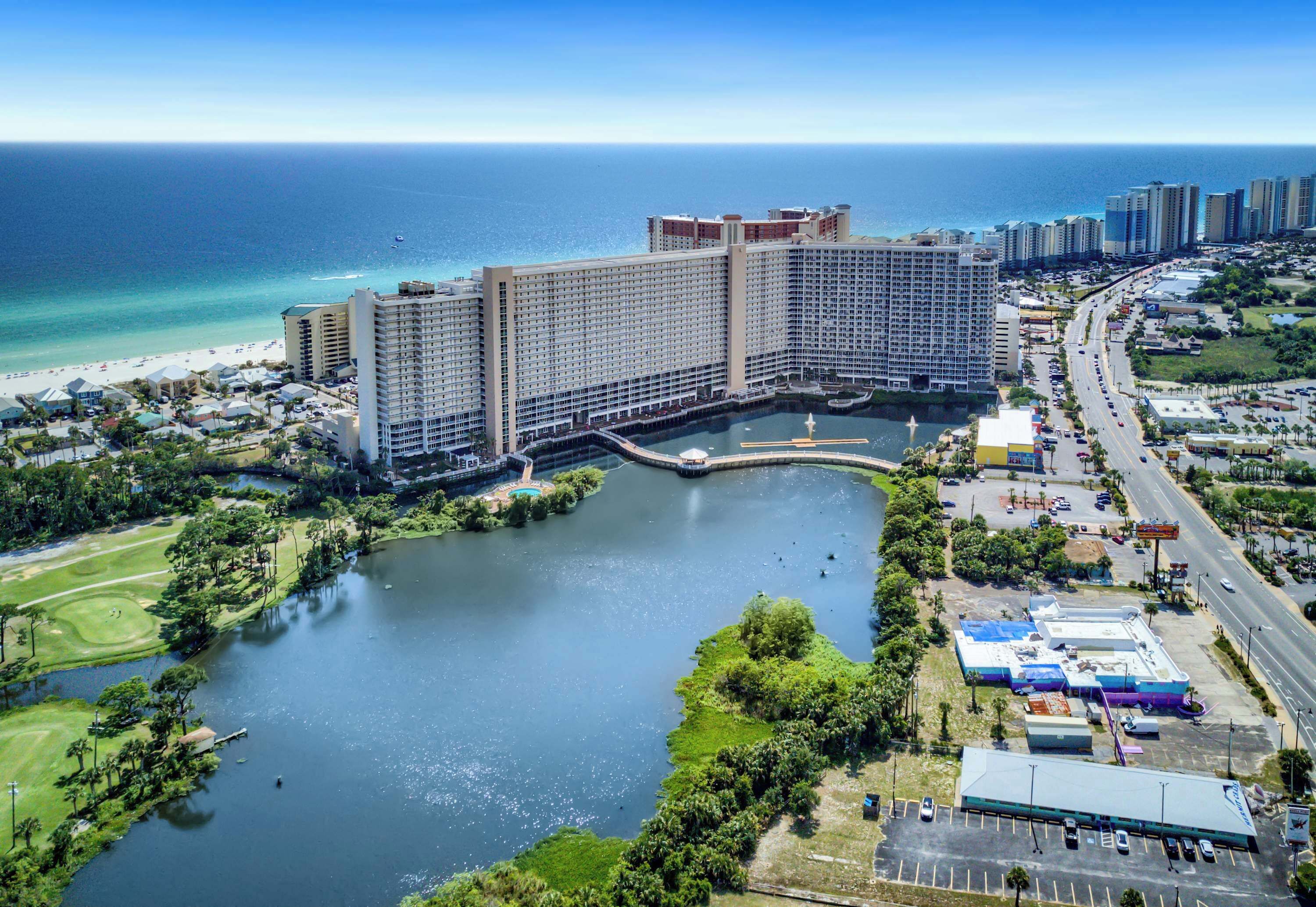 A large hotel with multiple buildings, a marina, and a beach.