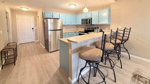A modern kitchen with a central island, stainless steel appliances, and light blue cabinets. - Highland Lake View Incredible Location! (Lake Ozark)