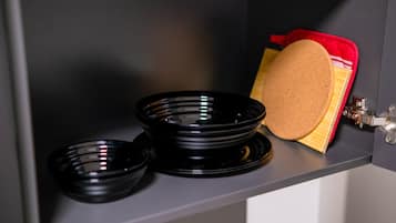 A kitchen counter with black bowls and a red container.
