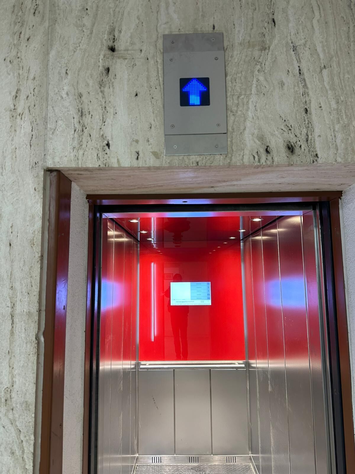 An elevator with a red interior and a digital display at the top.