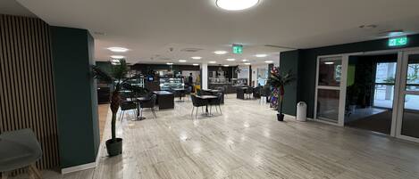 A spacious indoor area with a polished marble floor, multiple seating arrangements, and a central counter area.