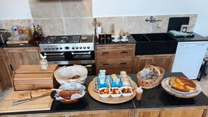 Une cuisine équipée d’une cuisinière, d’un four et d’un lave-vaisselle. On y trouve divers aliments et ustensiles de cuisine sur le plan de travail.