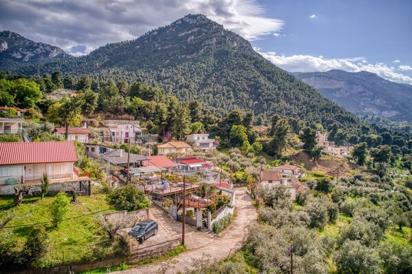 A hillside village with houses, a road, and a mountain in the background. - Magical View Studios 1 Asproneri, Kamena Vourla (Kamena Vourla)