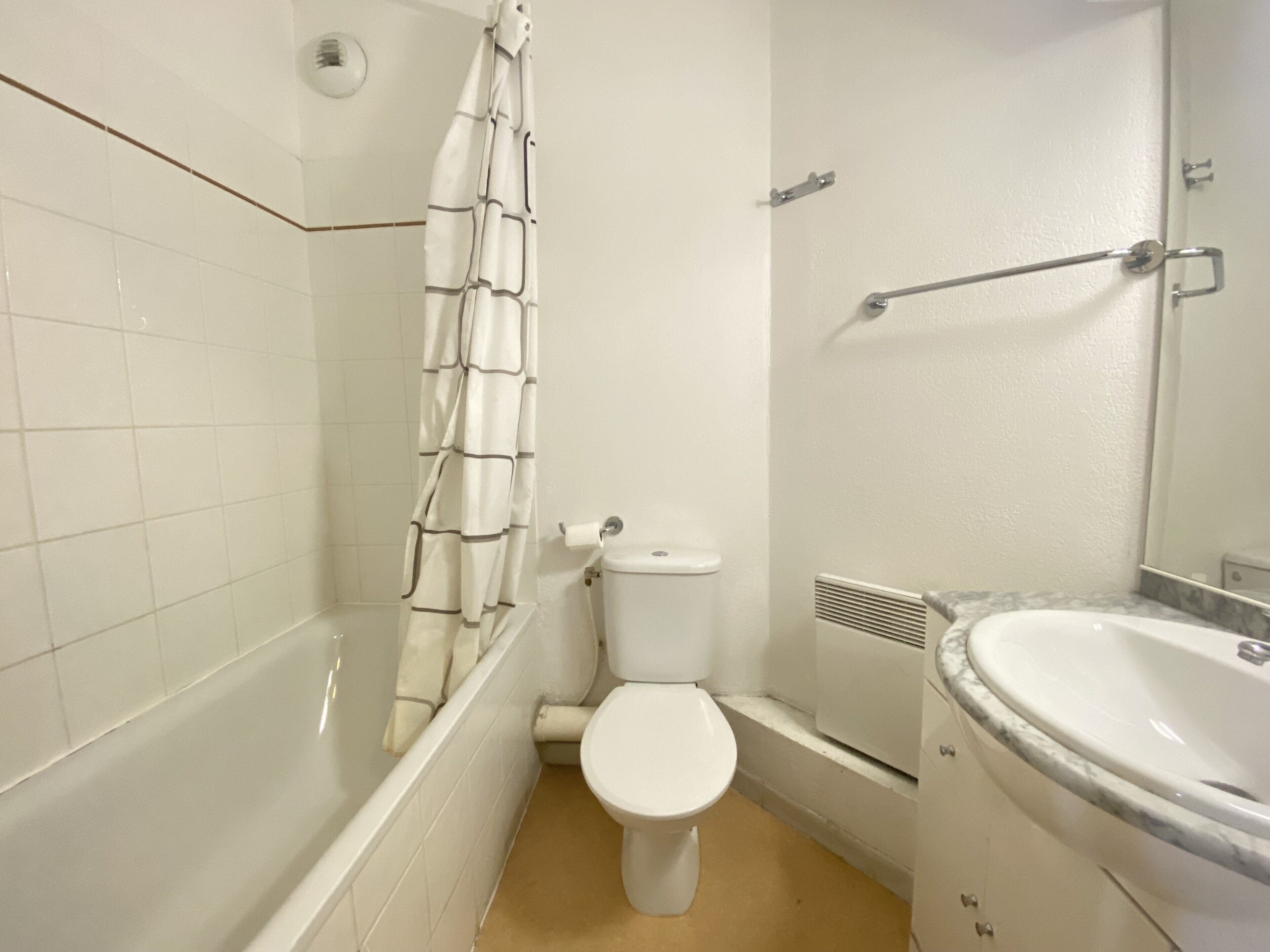 A bathroom with a bathtub, toilet, and sink.