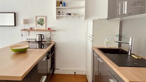 A compact kitchen with a wooden countertop, a built-in oven, a sink, and a white refrigerator. - Lovely bright cocoon - Hyper center de Lyon (Lyon)