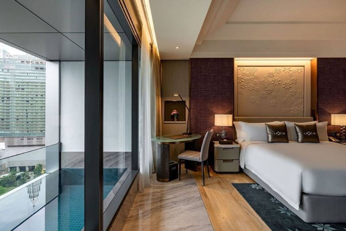 Een moderne hotelkamer met een groot bed, een bureau en uitzicht op de stad.