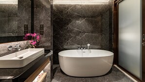 A modern bathroom with a freestanding bathtub, a large mirror, and a vanity with a sink. - Imperial Lexis Kuala Lumpur (Kuala Lumpur)