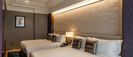 Een hotelkamer met twee bedden, een wandlamp en een lijst met een afbeelding aan de muur.