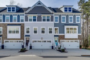 A multi-story residential building with a central garage door, a small porch with steps, and a mailbox. - 3 Mi to Ocean City Boardwalk: Townhome w/ 2 Decks (Berlin)