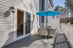 A deck with a table and chairs, a blue umbrella, and a white fence. - 3 Mi to Ocean City Boardwalk: Townhome w/ 2 Decks (Berlin)