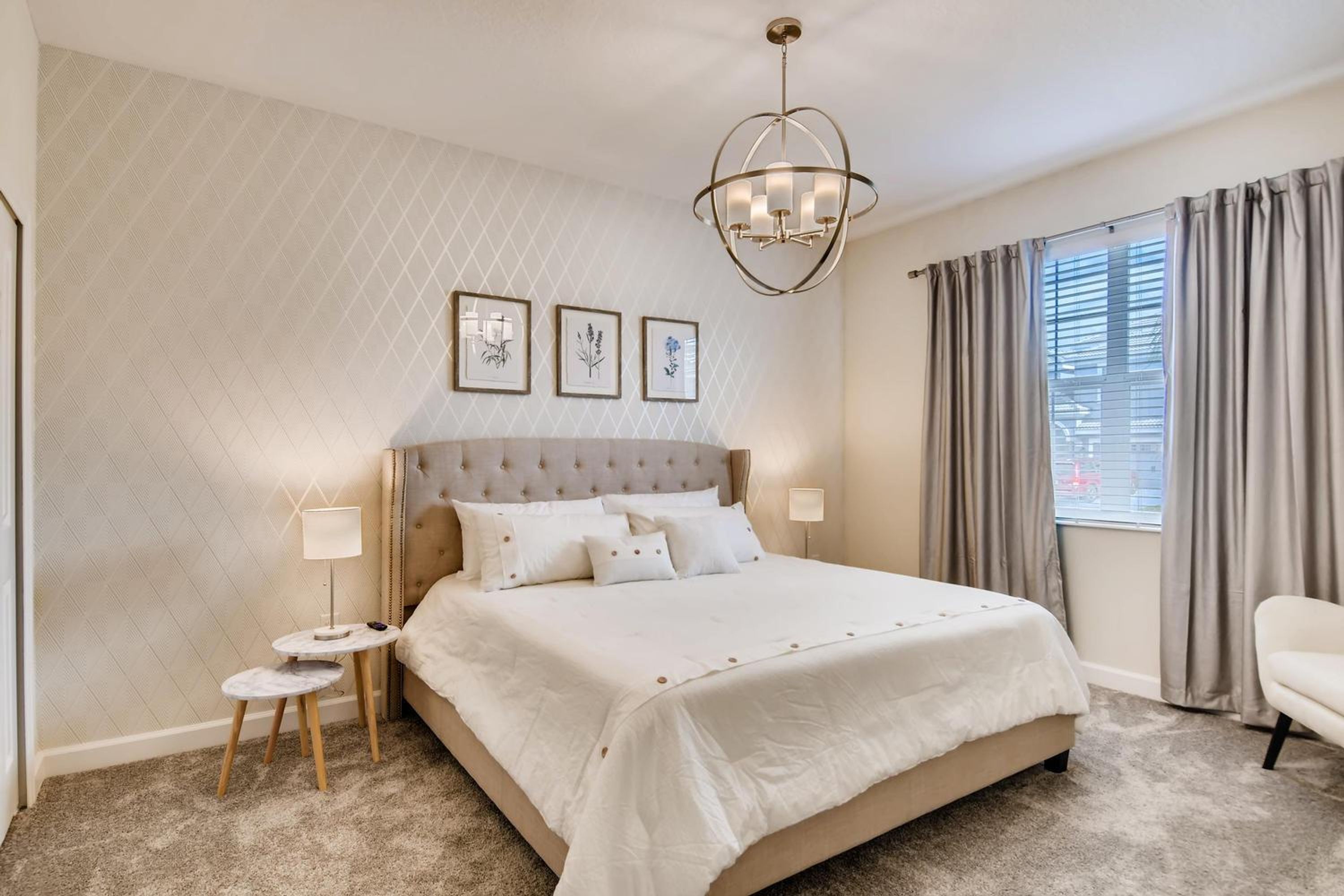 A bedroom with a large bed, a nightstand, a lamp, and a ceiling light.