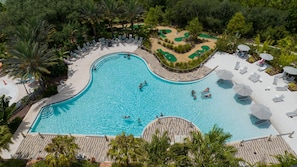 An aerial view of a swimming pool with a heart-shaped green area, surrounded by palm trees and lounge chairs. - 162 CD - 4-bed Retreat Pool Disney Magic (Davenport)