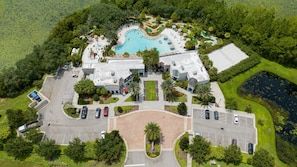 An aerial view of a resort with a swimming pool, tennis courts, and a parking area. - 162 CD - 4-bed Retreat Pool Disney Magic (Davenport)