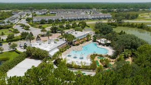 An aerial view of a resort with a large swimming pool, multiple buildings, and surrounding greenery. - 162 CD - 4-bed Retreat Pool Disney Magic (Davenport)