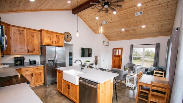 A modern kitchen with wooden cabinets, stainless steel appliances, and a central island.