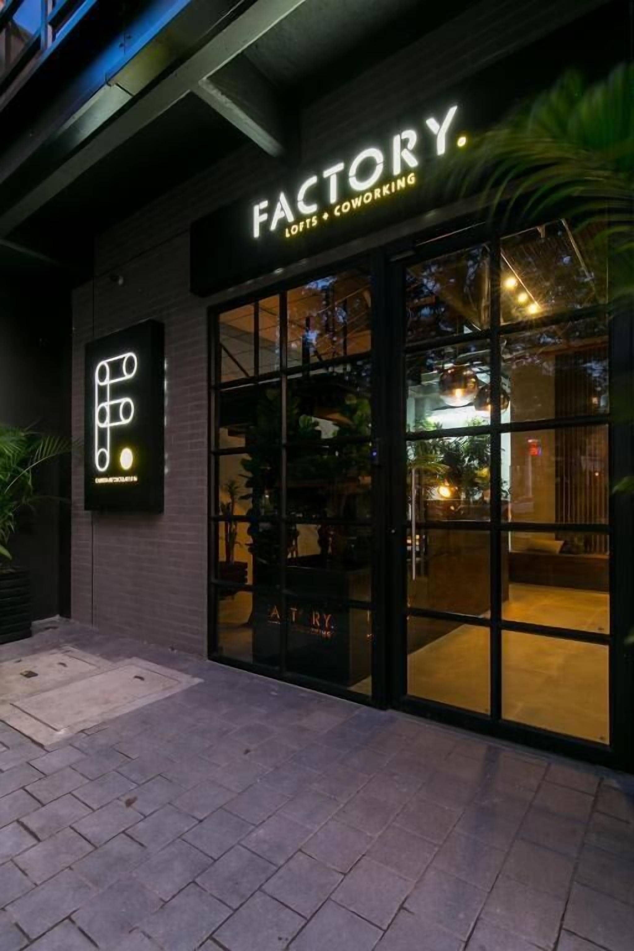 A building with a sign reading "FACTORY. LOUNGE + COWORKING."