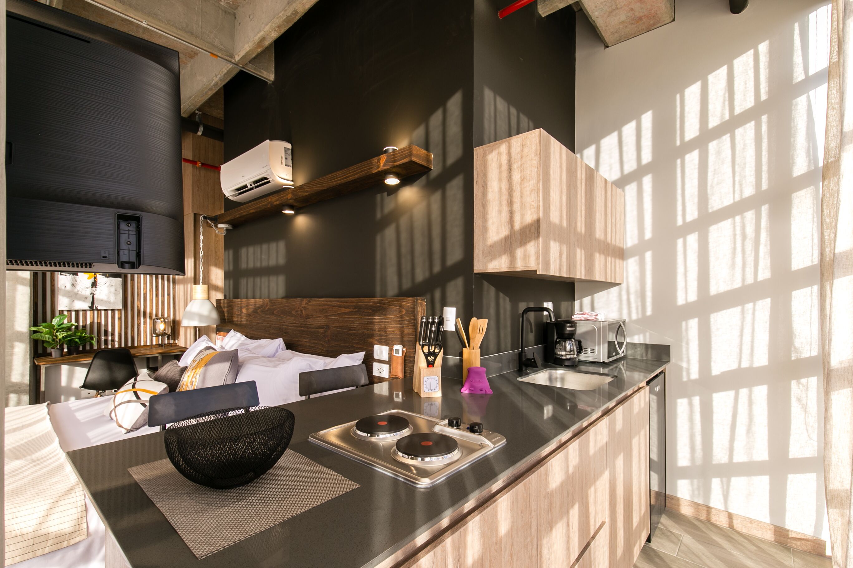 Una cocina moderna con horno empotrado, microondas y cafetera.