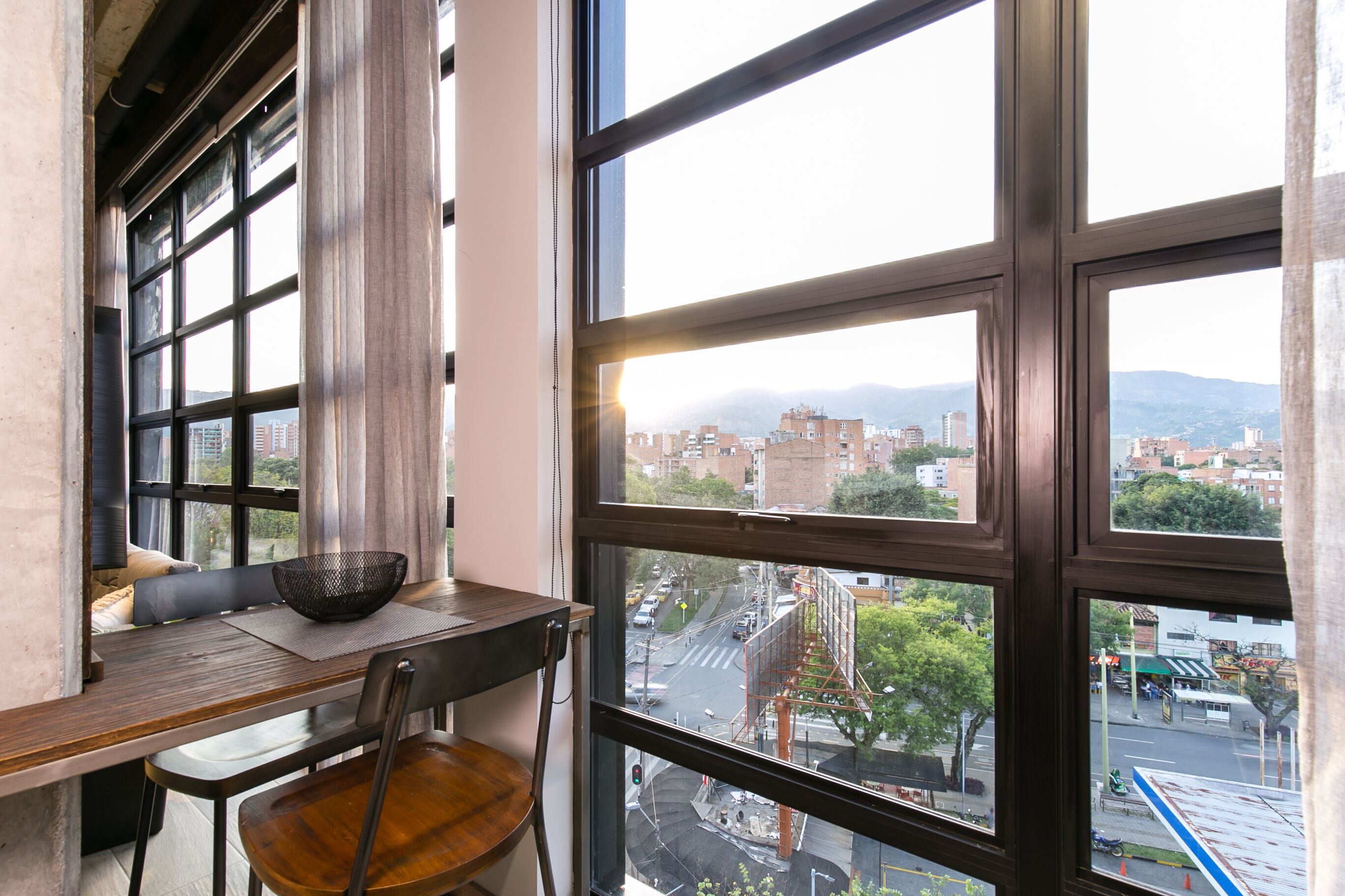A dining area with a view of a cityscape through large windows.