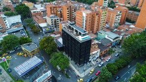 Urban landscape with a mix of residential and commercial buildings, featuring a prominent black building, a restaurant, and a gas station.