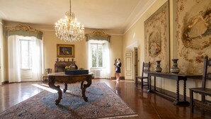 A spacious room with a large ornate chandelier, a patterned rug, and classic furniture. - CASTELLO DI SOVICILLE- RESIDENZA D'EPOCA (Sovicille)