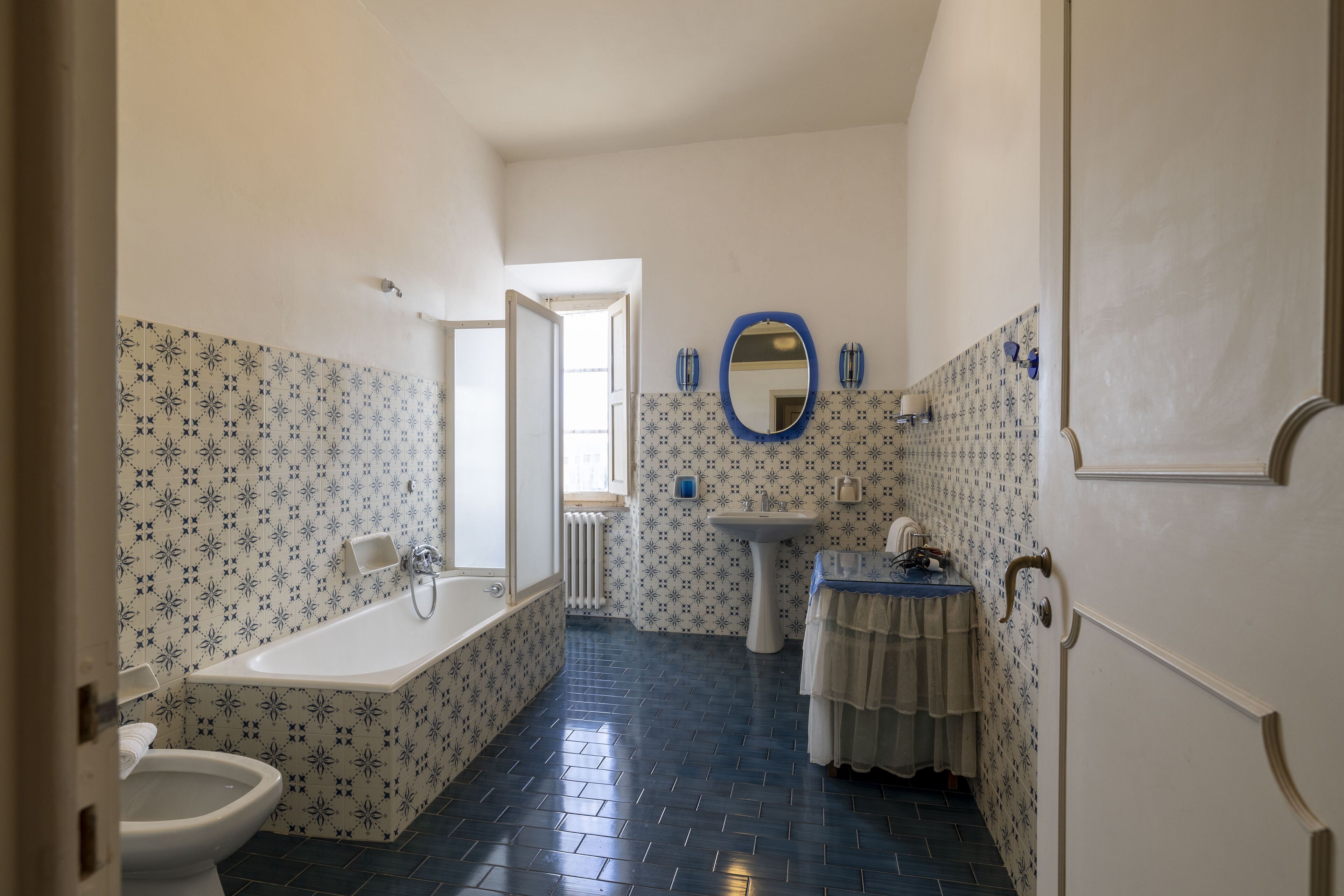 A bathroom with a bathtub, toilet, sink, and a mirror.