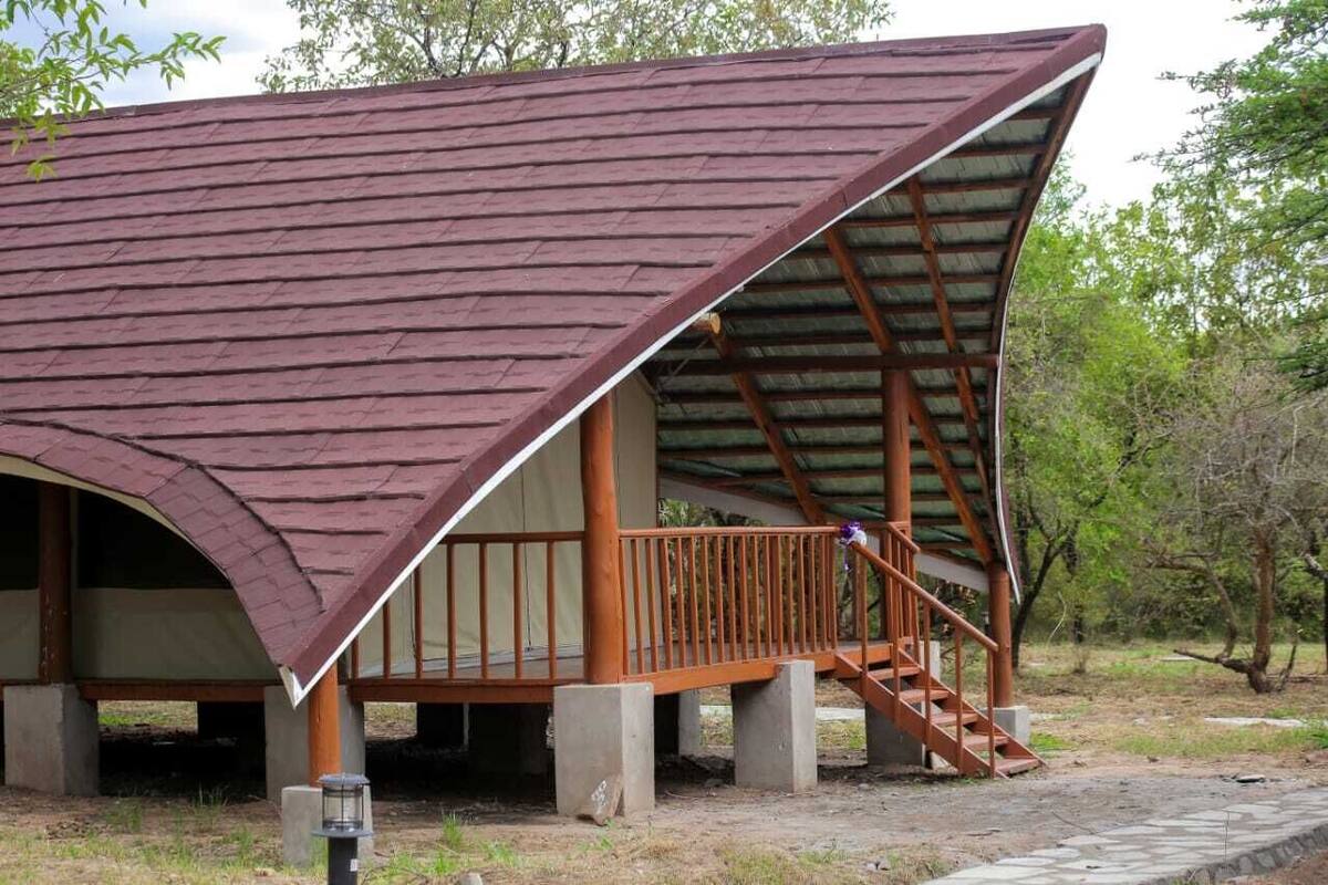Een paviljoen met een schuin dak en een houten hekwerk.