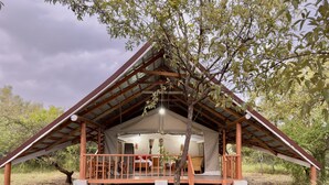Une structure rustique en forme de « A », dotée d’un porche abrité et d’un lit à l’intérieur.