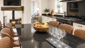 Una cocina moderna con una isla grande, una estufa y un televisor montado en la pared.