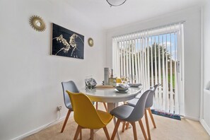 Enjoy meals with friends and family in this stylish dining area, featuring a round table and comfortable seating for four.