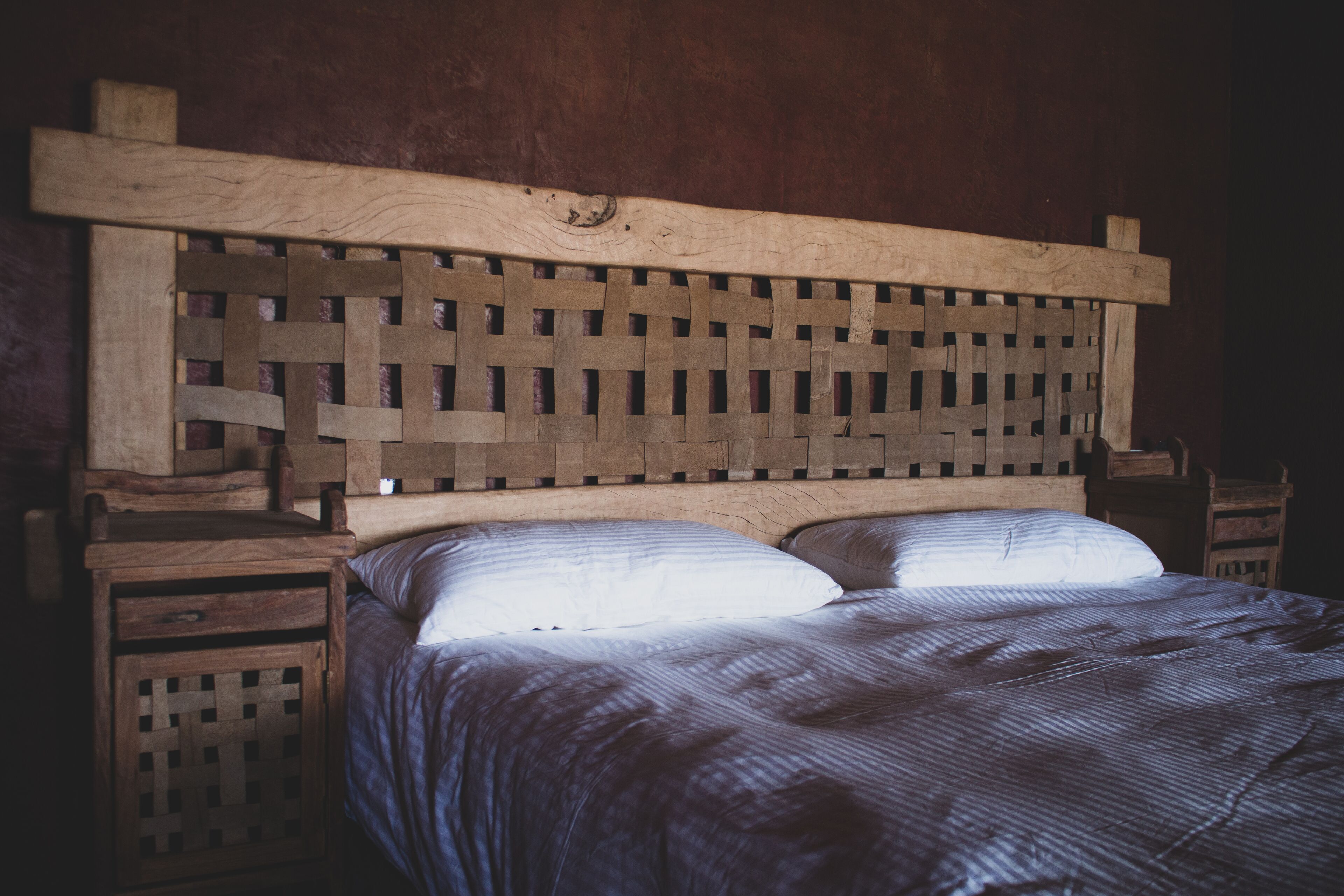 A bed with a wooden headboard and two nightstands.
