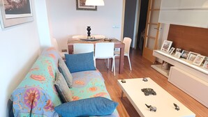 Un salon comprenant un canapé, une table basse et un coin repas avec des chaises et une table.